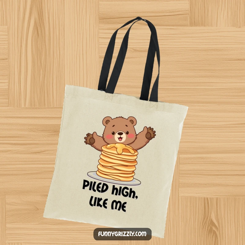 Funny tote bag with a grizzly bear attempting to balance on a wobbling stack of pancakes, perfect for carrying items with a smile.